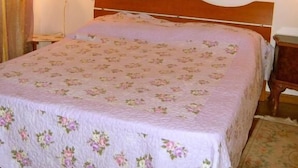 A bedroom with a wooden bed, a nightstand, a lamp, and three wall-mounted pictures. - CORTE BARBIERI (Ceraino)