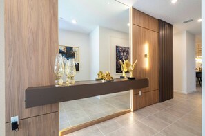 Ein modernes Interieur mit einer Holzpaneelausstattung, einer spiegelnden Fläche und einem Regal mit Dekoration.