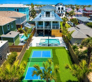 A residential property with a swimming pool, tennis court, and a fenced backyard. - SE907 4BD, 4.5BA, Private Heated Pool, Pickleball Court, Parking for 5 (Port Aransas)