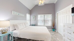 A bedroom with a bed, a nightstand, a dresser, a window with blinds, and a ceiling fan. - FH6, Near Beach, Shared Pool, Pet Friendly, Charcoal Grill (Port Aransas)