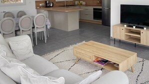 Ein modernes Wohnzimmer mit Sofa, Couchtisch und TV-Möbel.
