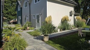 A residential property with a paved driveway, a lawn, and a variety of plants. - Comfortable Houses With Terraces (Rewal)