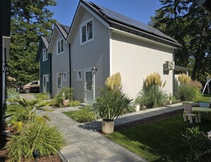 A residential property with a paved driveway, a lawn, and a variety of plants. - Comfortable Houses With Terraces (Rewal)
