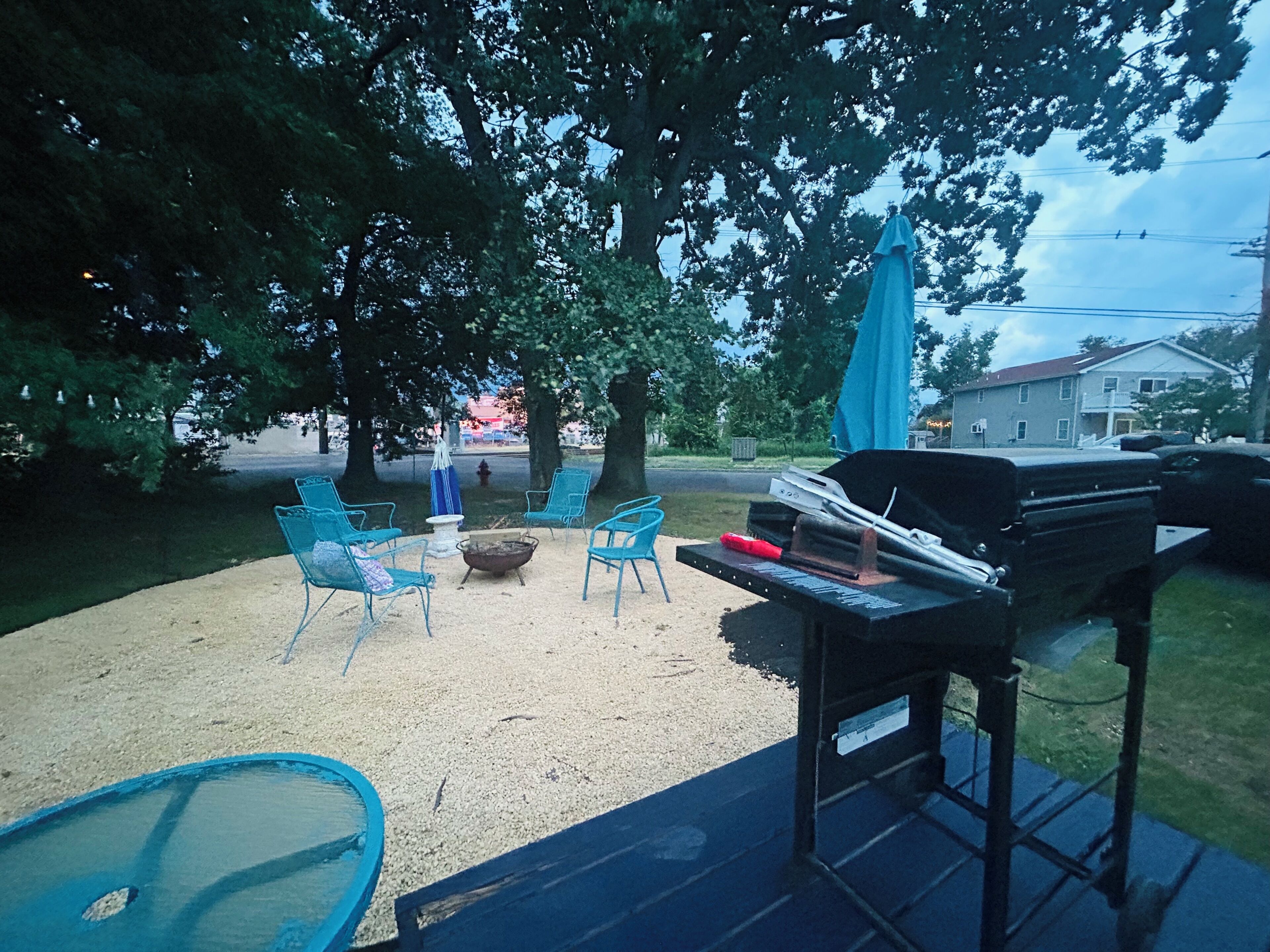 Eine Terrasse im Freien mit Grill, Stühlen und einem Feuerkorb.