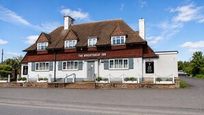 Perinteinen rakennus, jonka yläpuolella on kyltti, jossa lukee: »The Wheatsheaf Inn». Siinä on harjakatto, useita ikkunoita ja kivinen perustus.