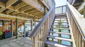 Eine Holzterrasse mit einer Treppe, die zu einem Steg über dem Wasser führt.