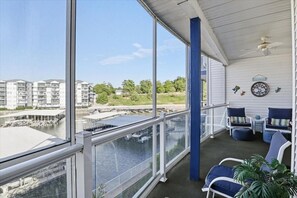 Ein Balkon mit Blick auf einen Yachthafen und Gebäude, ausgestattet mit Stühlen und einem Tisch.