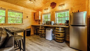 L'intérieur d'un chalet en bois comprend une cuisine, un coin bar et un espace salon.