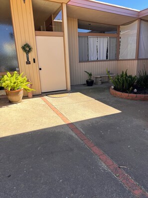 A building with a beige exterior, a gated entrance, and a paved driveway. - Large home located in the countryside with swimming pool and backyard pool room. (Woodland)