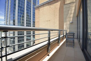 A balcony with metal railings, a view of a cityscape, and a building with a beige facade. - The Raphael Penthouse Suites (Johannesburg)