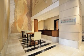 A lobby with a reception desk, a sign for 'Raphael Rest Rooms,' and a checkered floor. - The Raphael Penthouse Suites (Johannesburg)