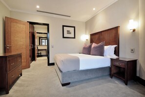 A bedroom with a bed, nightstands, a dresser, and a framed picture on the wall. - The Raphael Penthouse Suites (Johannesburg)