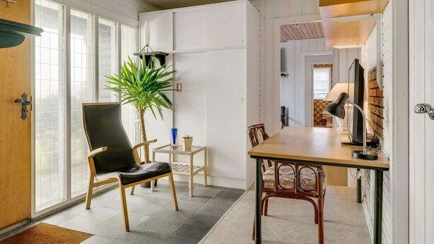 Ein modernes Interieur mit Essbereich, einer Topfpflanze und einem Fernseher.