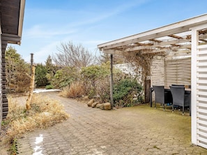 A covered outdoor area with a paved walkway, a grill station, and surrounding vegetation. - 4 Star Holiday Home in Hjorring (Hjørring)