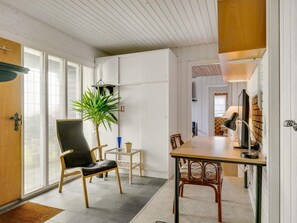 A modern interior with a dining area, a potted plant, and a view through a glass door. - 4 Star Holiday Home in Hjorring (Hjørring)