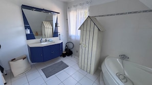 Ein Badezimmer mit Badewanne, Waschbecken, Spiegel und Duschvorhang.