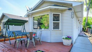 Une maison avec une terrasse, une balançoire et une antenne parabolique.