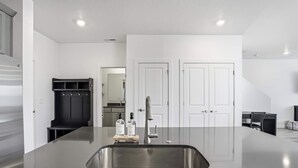 Een moderne keuken met een groot eiland, een roestvrijstalen spoelbak en een inbouwkast.