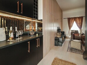 A modern kitchen with a bar area, a seating area with a sofa and armchairs, and a fireplace. - HANOWEN  HOUSE, pet friendly, with hot tub in Dungloe, County Donegal (Dungloe)