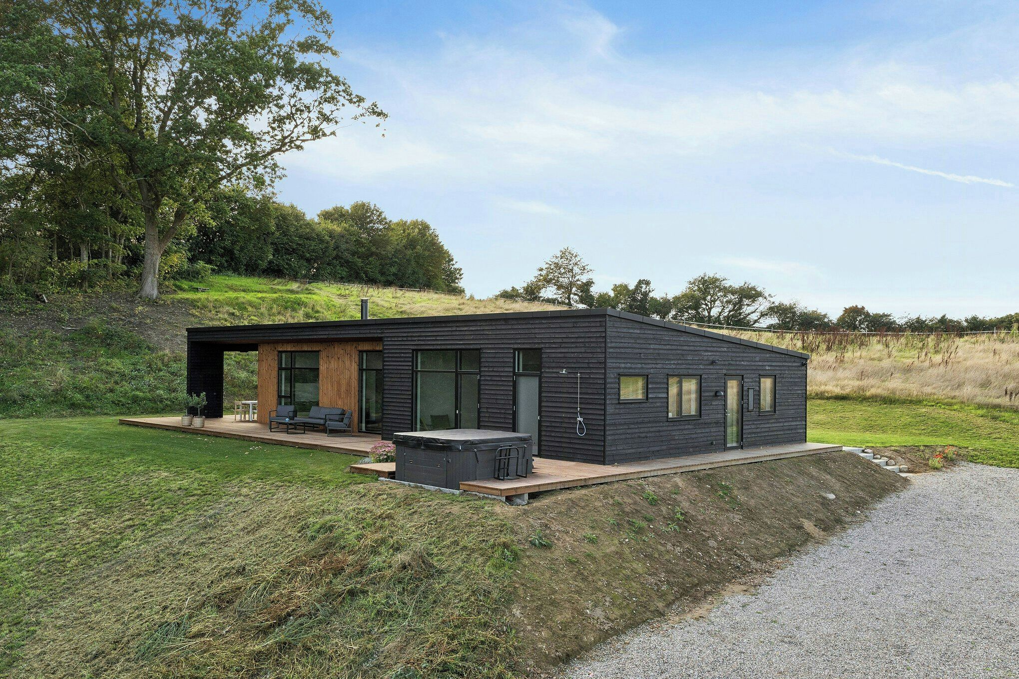A modern house with a flat roof, large windows, and a deck area.