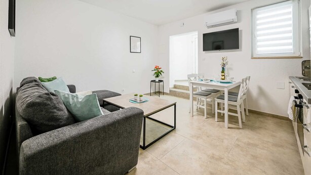 Ein Wohnzimmer mit einer Couch, einem Couchtisch und einem Essbereich mit Tisch und Stühlen.