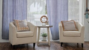 Ein Zimmer mit zwei Sesseln, einem kleinen Tisch und einem dekorativen Gegenstand in der Mitte.