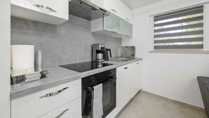 A modern kitchen with a built-in oven, a coffee maker, and a toaster. - Gasparevic Apartment 5 (Rovinj)