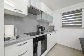 A modern kitchen with a built-in oven, a coffee maker, and a toaster. - Gasparevic Apartment 5 (Rovinj)