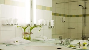 A bathroom with a large mirror, a sink, a shower, and a towel rack. - 2 Person Holiday Park Home in Dortmund (Dortmund)