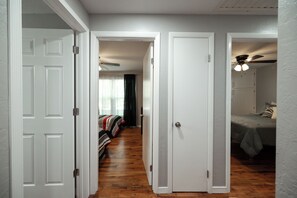 A hallway with two bedrooms, each with a bed and a ceiling fan. - Gorgeous 3 Bed 1.5 Bath House in Premium location (Springfield)