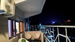 Ein Balkon mit zwei Stühlen, einem kleinen Tisch und einem Blumentopf.