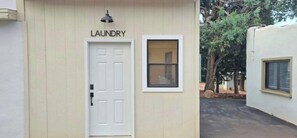 A building with a white door labeled 'LAUNDRY' and a window. - Homey Studio in Manitou Springs, Walk Downtown (Manitou Springs)