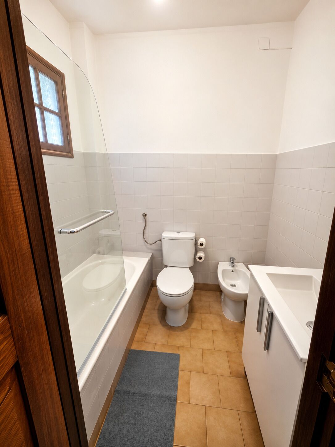 Un baño con bañera, inodoro, bidé y lavamanos.