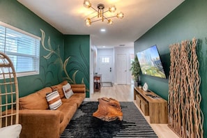 A modern living room with a brown sofa, a wooden coffee table, and a black rug. - Cozy 6BR Oasis, Fire Pit, Sleeps 13,Near DT (Houston)