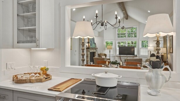 A modern kitchen with a large window, a stove, and a dining area visible in the reflection. - Wooded Highlands Cottage - Patios & Fireplace (Highlands)