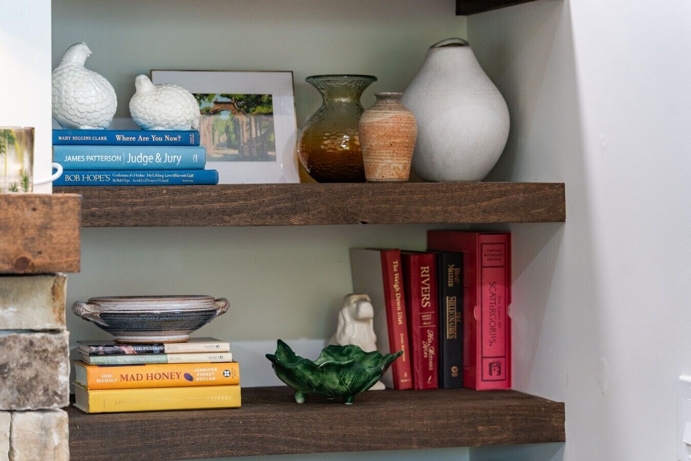 A bookshelf with books, decorative items, and a framed picture.