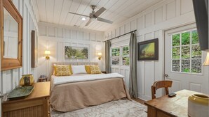 A bedroom with a bed, bedside tables, a desk, a chair, a ceiling fan, and a window with curtains. - Wooded Highlands Cottage - Patios & Fireplace (Highlands)