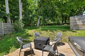 Eine Terrasse im Freien mit Tisch, Stühlen und einem Grill.