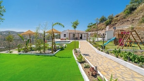 A residential property with a swimming pool, a children's play area, and a well-maintained lawn. - Casa Billota Torrox by Ruralidays (Málaga)