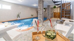 A poolside area with a table, two glasses of water, and a pitcher with cucumber slices. - El Sueño de la Libélula Torrox by Ruralidays (Málaga)