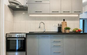 Eine moderne Küche mit Edelstahlgeräten, einem eingebauten Backofen und einem Spülbecken mit Armatur.