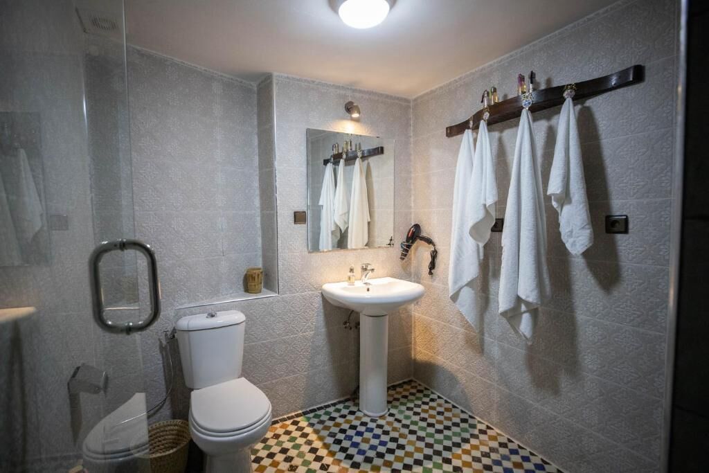 A bathroom with a toilet, sink, and shower.