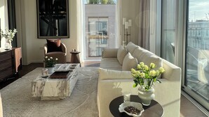 A modern living room with a sofa, a coffee table, and a large window. - The Brompton Residence (London)