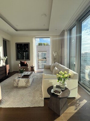 A modern living room with a sofa, a coffee table, and a large window. - The Brompton Residence (London)