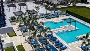 Un complexe hôtelier doté d’une piscine, de chaises longues et d’un parking.