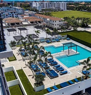 Ein Resort mit Swimmingpool, Liegestühlen und einem Parkplatz.