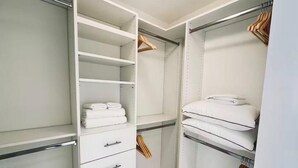 Un dressing avec des étagères ouvertes, une tringle pour suspendre les vêtements et des tiroirs.