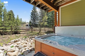 A hot tub outdoors with a wooden deck, a stone pathway, and a wooden fence. - Downtown WP River Villa 522 I Private Hot Tub I Great Views I Work Station I Discounted Attractions (Winter Park)