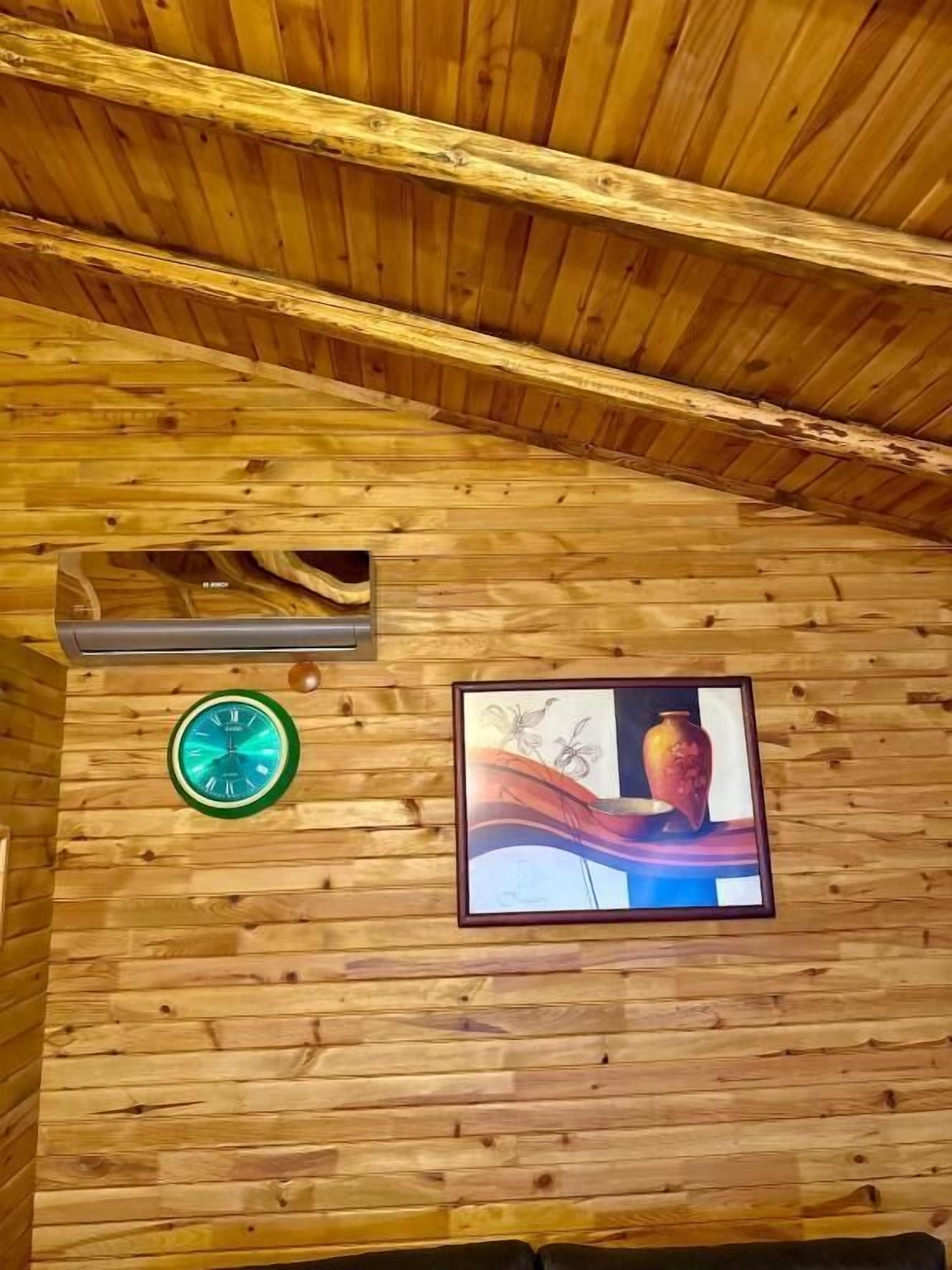 A wooden ceiling with a framed picture and a clock.