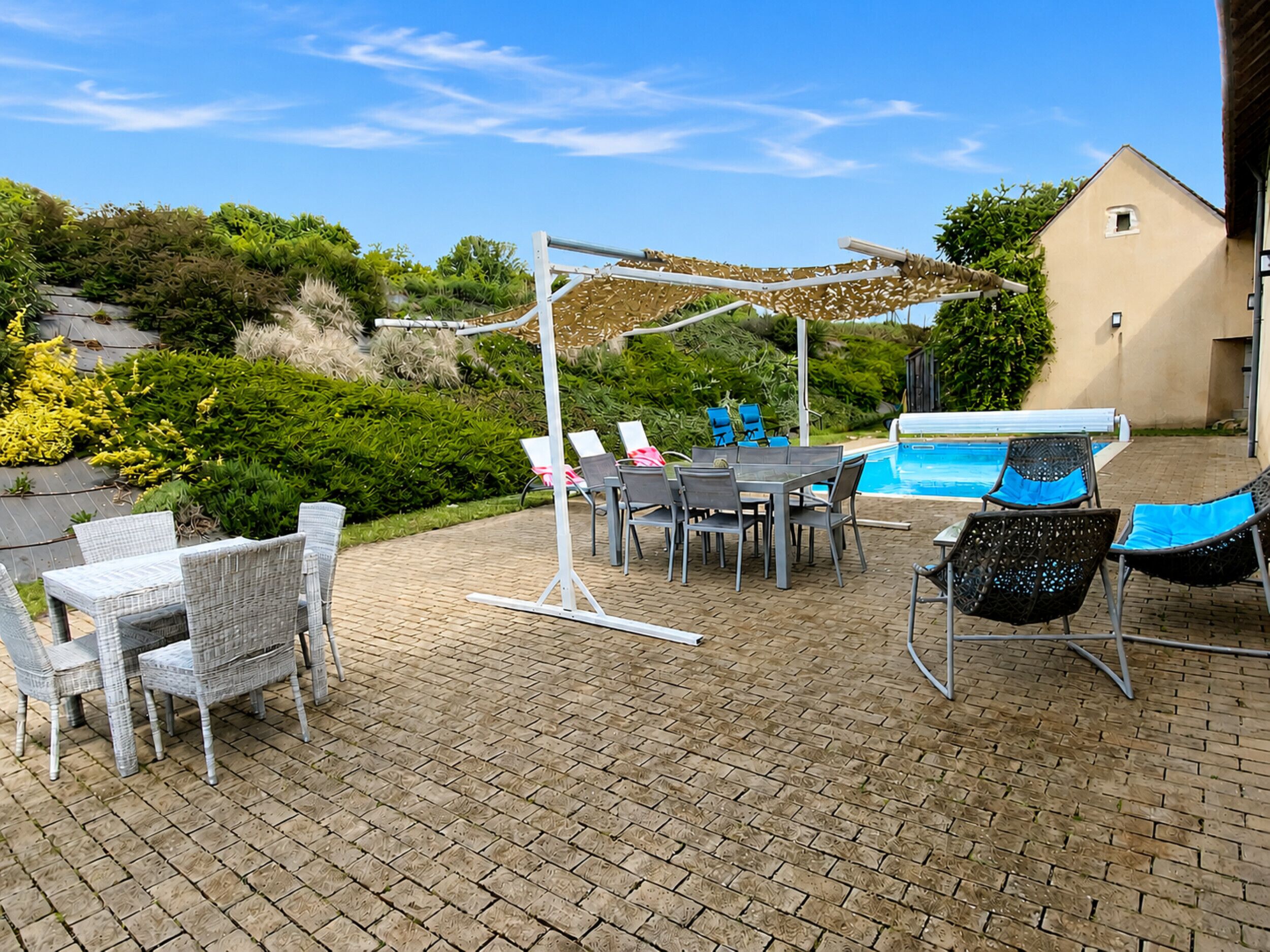 A patio with a pool, outdoor furniture, and a pergola.